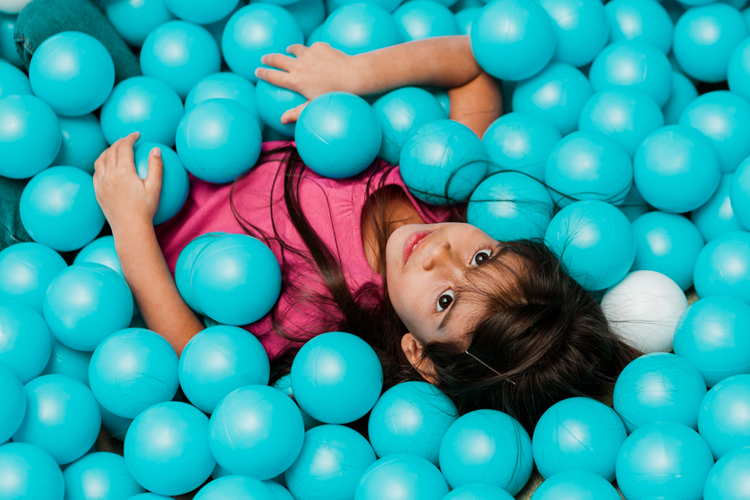 little girl laying down in a playground at a party